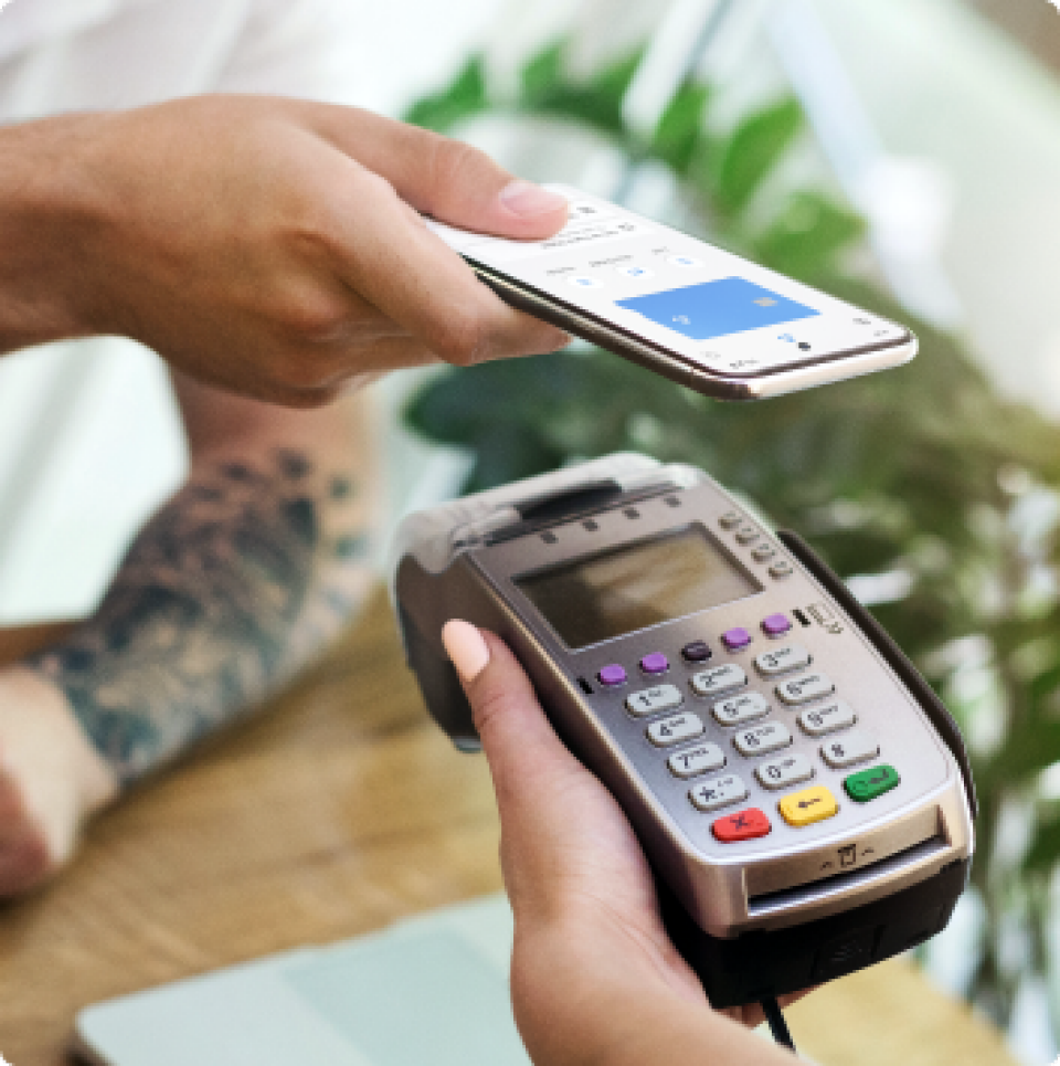 A person using their phone to tap and pay